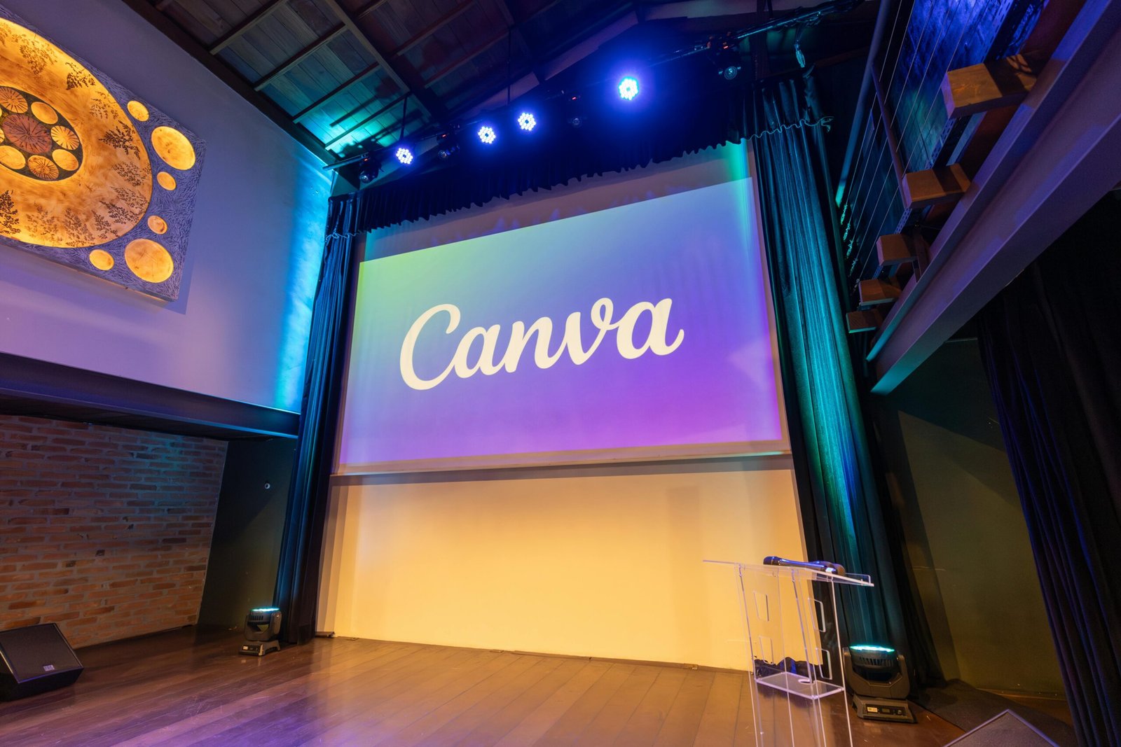 Stage setup with a large screen displaying Canva logo, ready for a presentation.